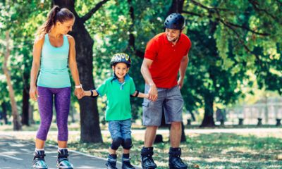 Family with one child roller skating in park