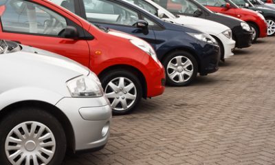 row of different european marques of used cars for retail sale on a motor dealers forecourt all logos removed