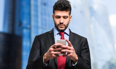 Businessman typing sms on his smartphone