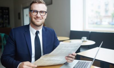 Job seeker with newspaper and laptop looking for vacancies